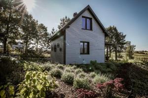 a small house with a garden in front of it at Domki na Kaszubach - Chabry i Rumianki - Roztoka, Przywidz - Basen Sauna Jacuzzi KASZUBY in Roztoka