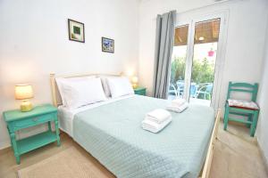 a bedroom with a bed and a chair and a window at Ninas Cottage in Línia