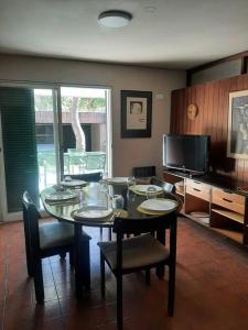 a dining room with a table and chairs and a television at Casa excelente ubicación in Mendoza