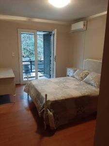 a bedroom with a bed and a large window at Casa excelente ubicación in Mendoza