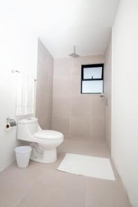 a white bathroom with a toilet and a window at Hotel Ventura in Quesada