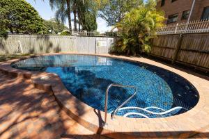 a swimming pool in a yard with a fence at Heritage 201 in Tuncurry