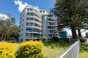 a white apartment building with a white fence at Heritage 201 in Tuncurry