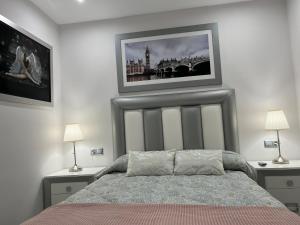 een slaapkamer met een bed en twee schilderijen aan de muur bij APARTAMENTO 128 ESPINEL in Ronda