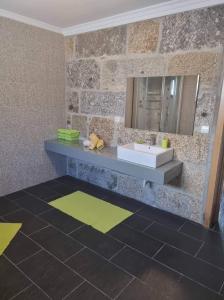 y baño con lavabo y espejo. en Modern Three Bedroom House en Figueiró