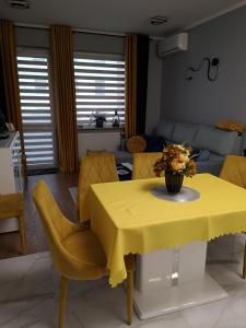 a yellow table with yellow chairs and a yellow table cloth at D&A Apartament in Szczecinek