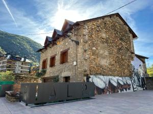 ein Backsteingebäude mit Graffiti nebeneinander in der Unterkunft Piso Rialp con vistas in Rialp