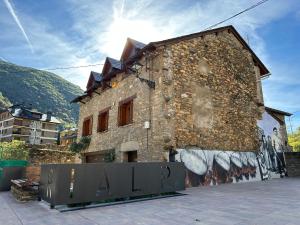 a brick building with graffiti on the side of it at Piso Rialp con vistas in Rialp