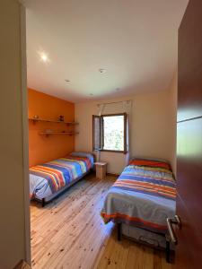 two beds in a room with wooden floors at Piso Rialp con vistas in Rialp