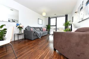 a living room with a couch and a table at Lavender House Apartments Limehouse Docklands in London