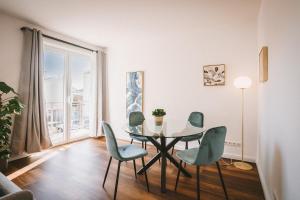 ein Esszimmer mit einem Tisch, Stühlen und einem Fenster in der Unterkunft Sadebo Apartments Lübeck mit Terrasse oder Balkon in Lübeck