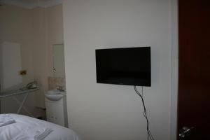 a flat screen tv on a wall in a bedroom at Kensington and Chelsea grand apartment in London