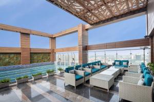 una piscina con sillas y una piscina en Radisson Blu Towers Kaushambi Delhi NCR, en Ghaziabad