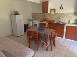 a kitchen with a table and chairs and a refrigerator at Logement vacances Gissac Sainte-Anne in Sainte-Anne