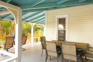 a porch with a wooden table and chairs at Canary Cottage in Oak Bluffs