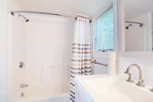 ein weißes Badezimmer mit Dusche und Waschbecken in der Unterkunft Canary Cottage in Oak Bluffs + 20 Fotos