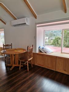 ein Esszimmer mit einem Tisch und einem Fenster in der Unterkunft Departamento Rossbach in Puerto Puyuhuapi