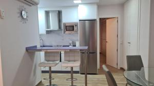 cocina con encimera con taburetes y nevera en Apartamento 128 Espinel 2, en Ronda