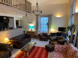 a living room with leather furniture and a chandelier at The Old Court House & Jail in Menai Bridge