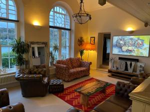 a living room with couches and a flat screen tv at The Old Court House & Jail in Menai Bridge