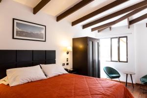 a bedroom with a large orange bed and two chairs at Hostal & Apartments El Triunfo in Cusco