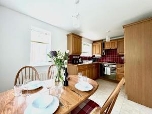 una cocina con una mesa de madera con platos y flores en Comfortable 3 bedroomed house in Bicester en Bicester