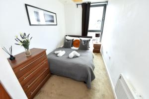 a bedroom with a bed with two towels on it at Lavender House Apartments Limehouse Docklands in London