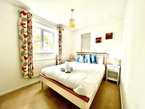 a bedroom with a bed and a window at Comfortable 3 bedroomed house in Bicester in Bicester