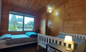 a bedroom with two beds in a log cabin at Tongariro Estate in National Park