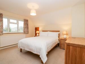 a bedroom with a large white bed and a window at Lanes End in Sherborne