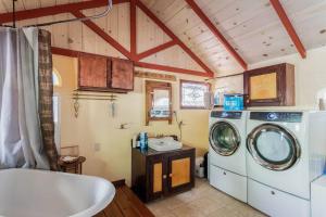 a bathroom with a washing machine and a sink at Tranquil creek mountain house in Los Gatos