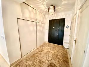 einen Flur mit einem großen Zimmer mit einer großen Wand in der Unterkunft Tulipe appartement in Oran