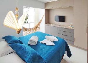1 dormitorio con 1 cama azul y TV en House Aconchegante Ponta Negra en Natal
