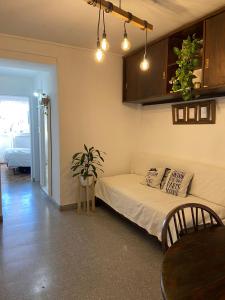 1 dormitorio con cama blanca, mesa y planta en DEPTO COLON en Mar del Plata