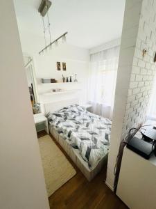 a white bedroom with a bed and a window at Giżycko Apartament 100m od plaży in Giżycko