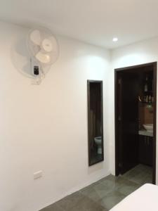 Habitación blanca con ventilador y espejo. en Confortable, en Guayaquil