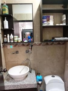y baño con lavabo, aseo y espejo. en Confortable, en Guayaquil