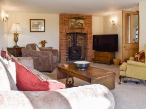 a living room with a couch and a fireplace at Beech Cottage in Somersal Herbert