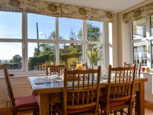 a dining room with a table and a large window at Beech Cottage in Somersal Herbert