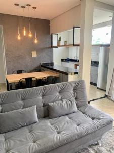 ein Sofa im Wohnzimmer mit einem Tisch und einer Küche in der Unterkunft Lindo apartamento em frente a UFOP com garagem in Ouro Preto