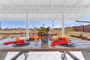 a wooden table with plates and utensils on it at Shooting Star Lodge in Joshua Tree