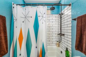 a bathroom with a shower curtain and a tub at Shooting Star Lodge in Joshua Tree +44 photos