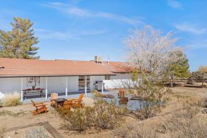 a house with a yard with chairs and a table at Shooting Star Lodge in Joshua Tree