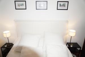 ein Schlafzimmer mit einem weißen Bett mit zwei Lampen in der Unterkunft Amazing Location CORUÑA DOWNTOWN in A Coruña