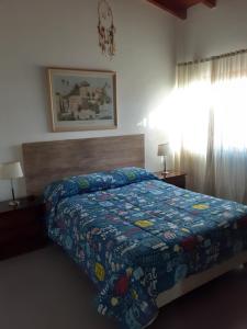 a bedroom with a bed with a quilt on it at Casa Santa Elena in Malargüe