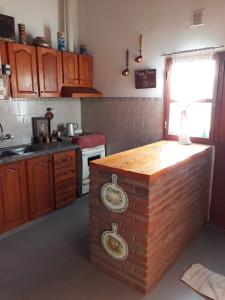 uma cozinha com um balcão de madeira no meio em Casa Santa Elena em Malargüe