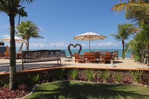 une terrasse avec une table et des chaises et l'océan dans l'établissement Villa Maravilha, à Arraial d'Ajuda