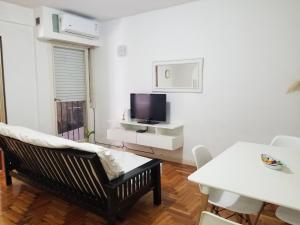 sala de estar blanca con sofá y TV en Italo Apt en Buenos Aires