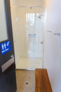 a shower with a glass door in a bathroom at Binna Burra Rainforest Campsite in Beechmont
