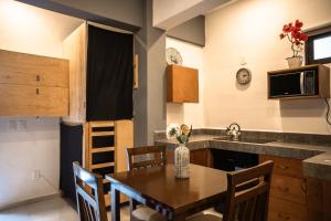 - une cuisine et une salle à manger avec une table et un évier dans l'établissement Maui Hostels Playa del Carmen, à Playa del Carmen